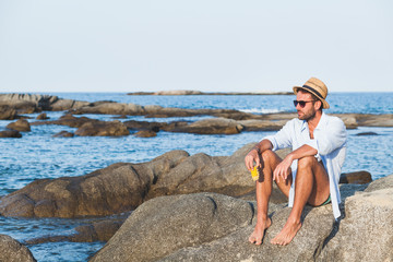 Young man eating corn on the beach © marjan4782