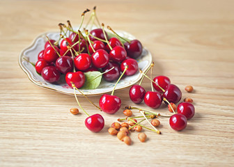 Plate of cherries on a wooden background.