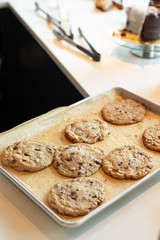 Freshly baked chocolate chip cookies on parchment line baking sheet with space for text on top