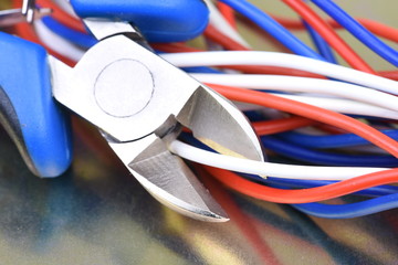 Pliers cutting electrical wires closeup