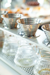 Row of metal pour over coffee maker with glass carafes 