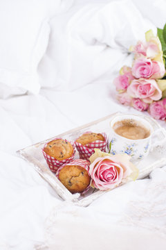 white bed, fresh coffee, breakfast cakes and a bouquet of pink roses. Good morning Vintage photo. Copy space.