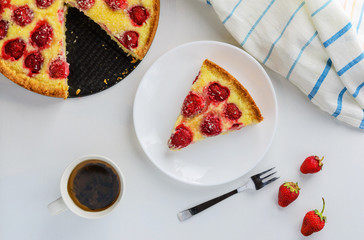 Slice of strawberry pie with a cup of tea on the table