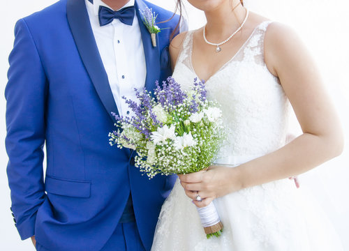 Elinde &ccedil;i&ccedil;ek tutan, g&ouml;vdenin yarısı g&ouml;r&uuml;n&uuml;n gelin ve damat,