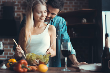 Beautiful young couple preparing a healthy meal together while spending free time at home.