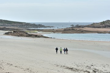 Une famille qui se promène sur la plage de la grève Blanche à Trégastel en Bretagne