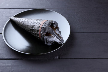 Black ice cream on a black plate with chocolate ice cream in a waffle cone, stylish summer dessert...