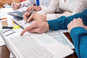 Advisors help in filling 1040 form, teamwork in office