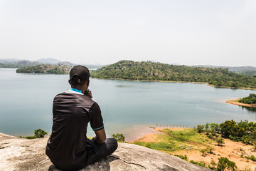 A young black male looks on at the mountains, rivers, wild and the metaphorically, the future.