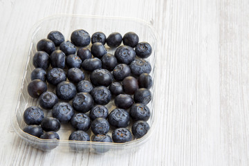 Blueberries in a plastic box, side view. Copy space.