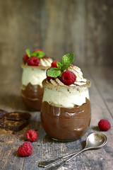 Chocolate mousse with whipped cream and fresh raspberry.