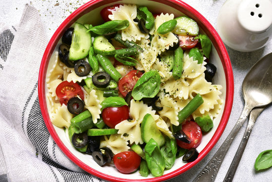 Pasta salad with vegetable (green bean, cucumber, tomatoes and olive).Top view.
