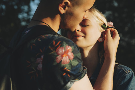 Beautiful couple with flower standing at sunset
