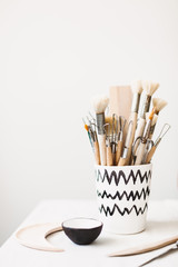 Close up modern handmade mug with pottery tools at studio isolated