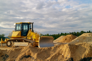 Obraz premium Bulldozer preparing terrain for building a road in the sunset.