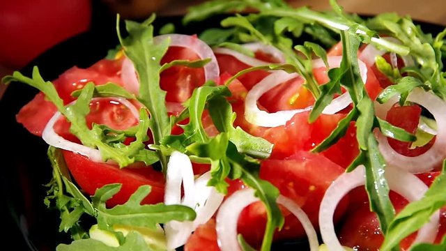 Salad from arugula and tomatoes turn around close-up