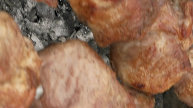 Barbeque skewers with meat cooking on hot coal ember brazier Outdoors picnic concept. Vertical format video.