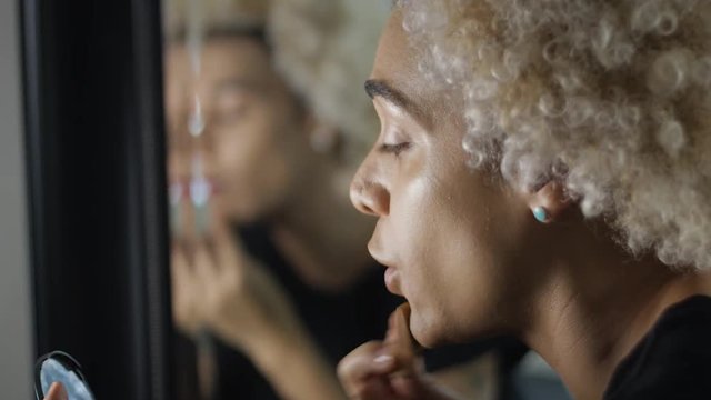 Transgender woman putting make up on and talking