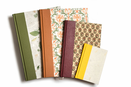 Four handmade, quarter bound books against a white background.