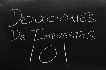 The words Deducciones De Impuestos 101 on a blackboard in chalk.  Translation: Tax Deductions 101