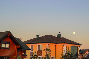 sunset in the village and the moon in the blue sky