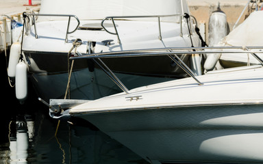 closeup on elements of yachts and motor boats anchored in the harbor, hot day at harbor