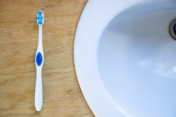 Blue toothbrush on bathroom counter next to sink
