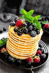 Pancakes with fresh berries. Pancakes with raspberry, blueberry, black currant and honey