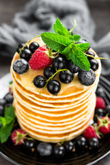 Pancakes with fresh berries. Pancakes with raspberry, blueberry, black currant and honey