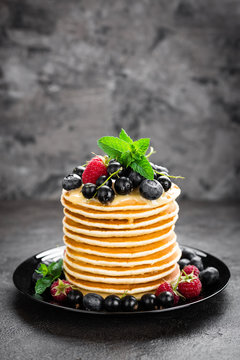 Pancakes with fresh berries. Pancakes with raspberry, blueberry, black currant and honey
