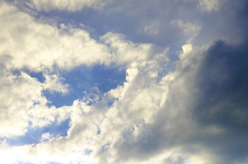 Clouds background, one part sunny, one part dark clouds 