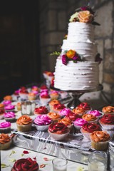 a beautiful wedding cake and cupcakes