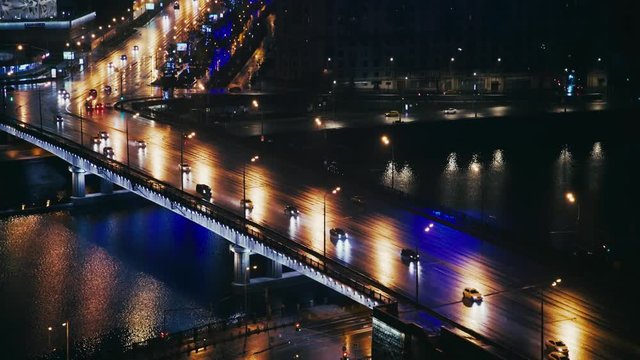 Cars riding across the river near the Arbat in Moscow, Russia. Summer night. Big city life concept. Locked down real time medium shot