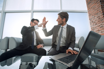 two businessmen giving each other a high five