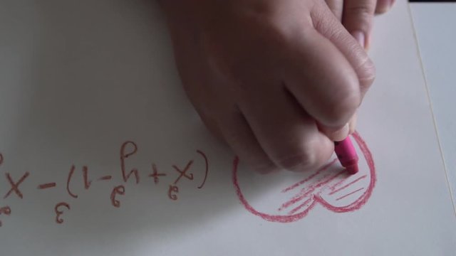 Students doing homework in math and drawing formulas to solve equations on paper in the classroom. Studying learning in school