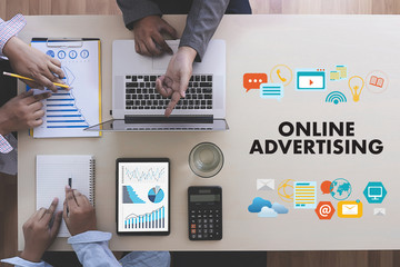 ONLINE ADVERTISING Business team hands at work with financial reports and a laptop
