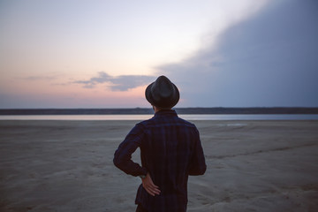 Rear view of young man looking on scenic sunset over sea