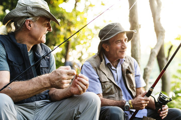 Senior friends fishing by the lake