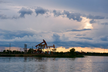 The oil pumping units and cloudscape sunset.
