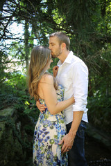 Romantic Couple Side view portrait of a Young Caucasian Couple in an Embrace with Natural Lighting Outside on a Spring or Summer Day