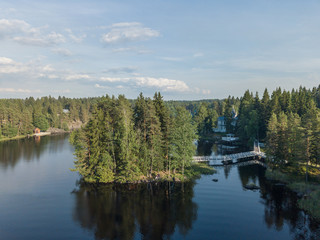Aerial view of the forest lake with white bridges above the water leading to the islands 