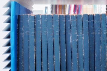 The old books in the library. Selective focus with blurred books in bookshelves background. Education and book's day concept. 