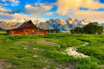 Mormon row with the Grand Tetons in the background is one of the most popular destinations in Jackson Hole Wyoming. - obrazy, fototapety, plakaty