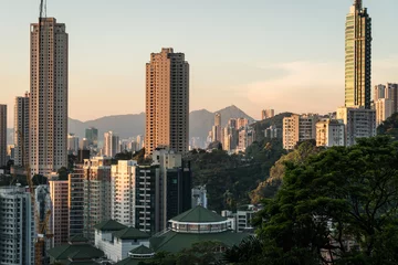 Papier Peint photo Hong Kong Coucher de soleil sur une grande tour d& 39 appartements à Happy Valley sur l& 39 île de Hong Kong avec les pics de Kowloon à l& 39 arrière à Hong Kong, Chine