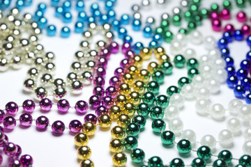 Macro view of bright colorful Mardi Gras beads with bokeh arranged in random fashion