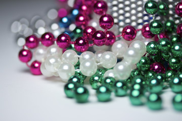 Macro view of bright colorful Mardi Gras beads with bokeh arranged in random fashion