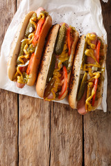 Chicago style hot dog with mustard, tomatoes, pickled cucumbers, onions and sauce close-up....