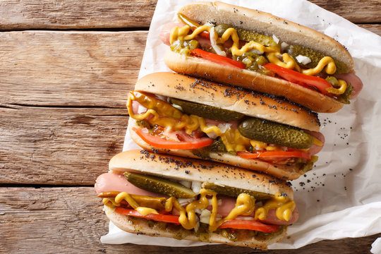 Traditional Chicago style hot dog with mustard, vegetables and sauce close-up. Horizontal top view