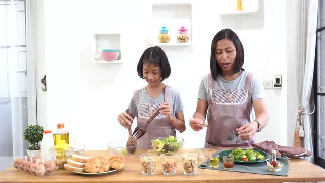 Mother and daughter cooking in the kitchen at home, happy family asian concept