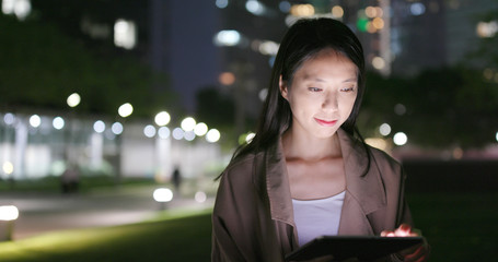 Business woman watch on tablet computer at night